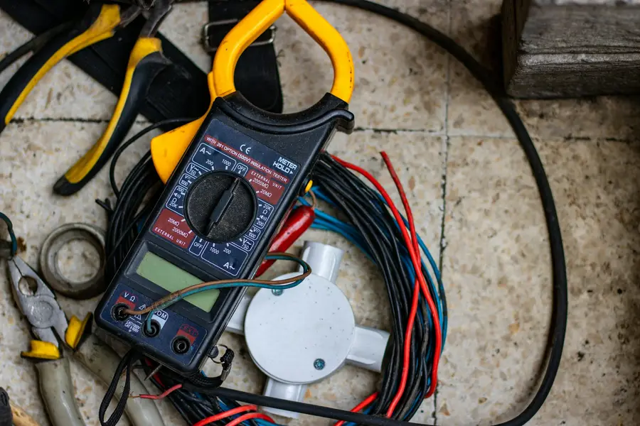 A clamp meter and cables on a workshop floor