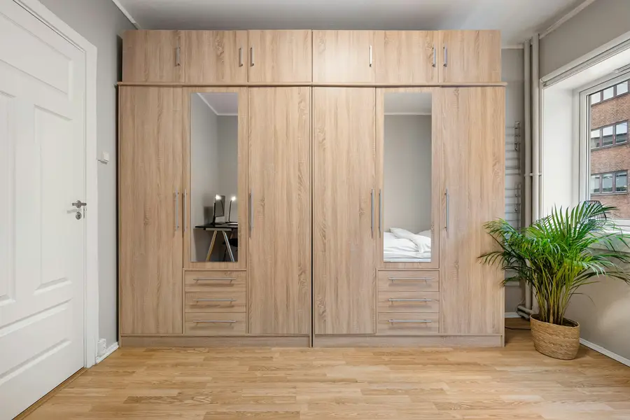 A wall of oak fitted wardrobes with mirrored doors