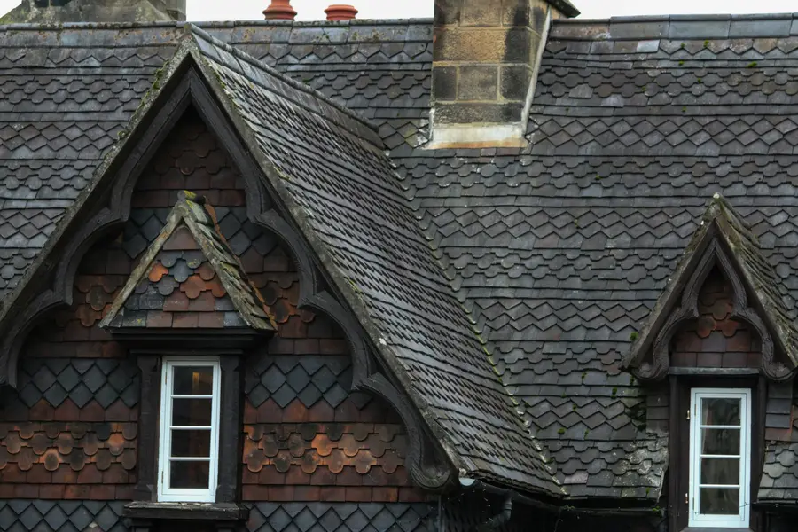 A slate roof with two gabled dormer windows