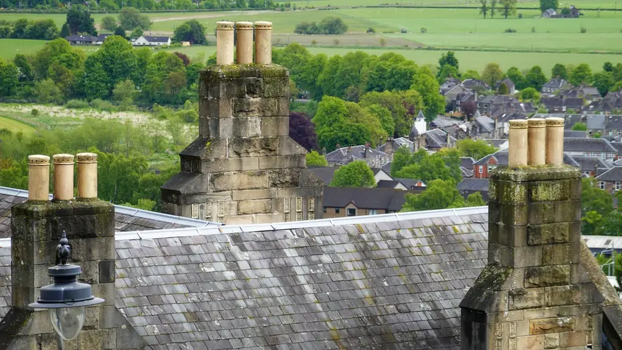 Stone chimneys on a slate roof above a town