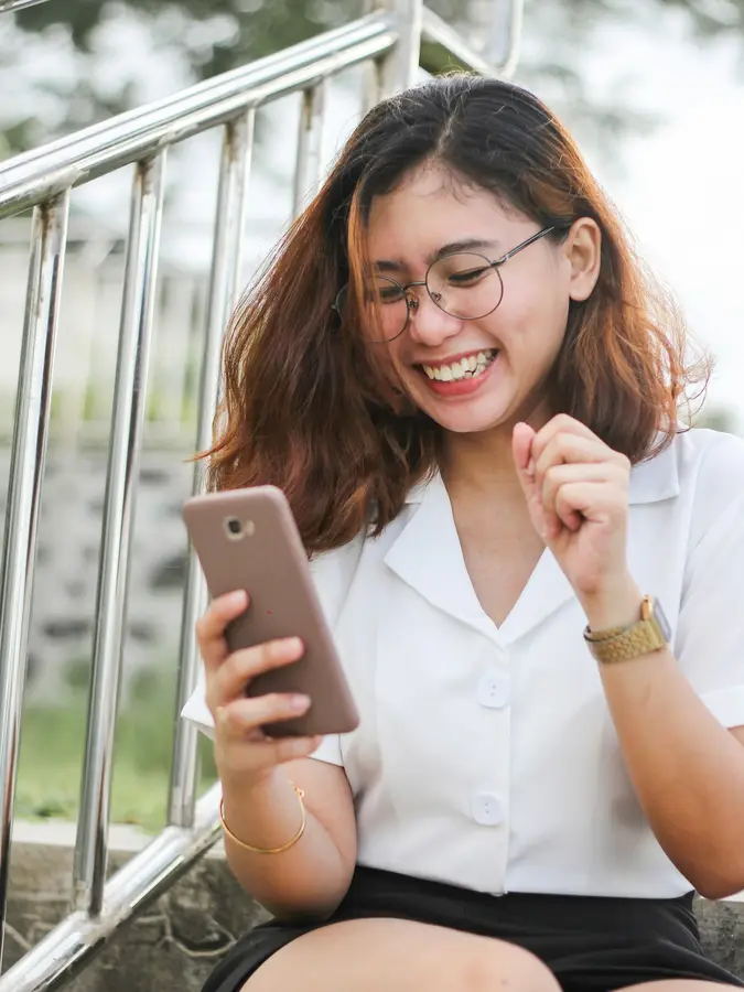 A customer smiling at a text on her phone